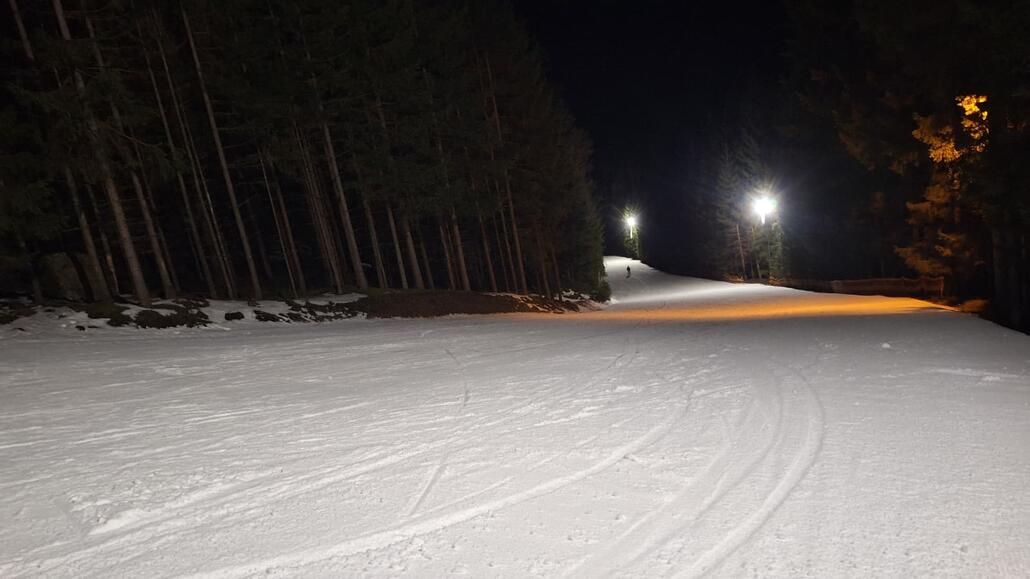 Selber Standpunkt, nur nach unten fotografiert. Flach läuft die Piste zur Talstation aus.