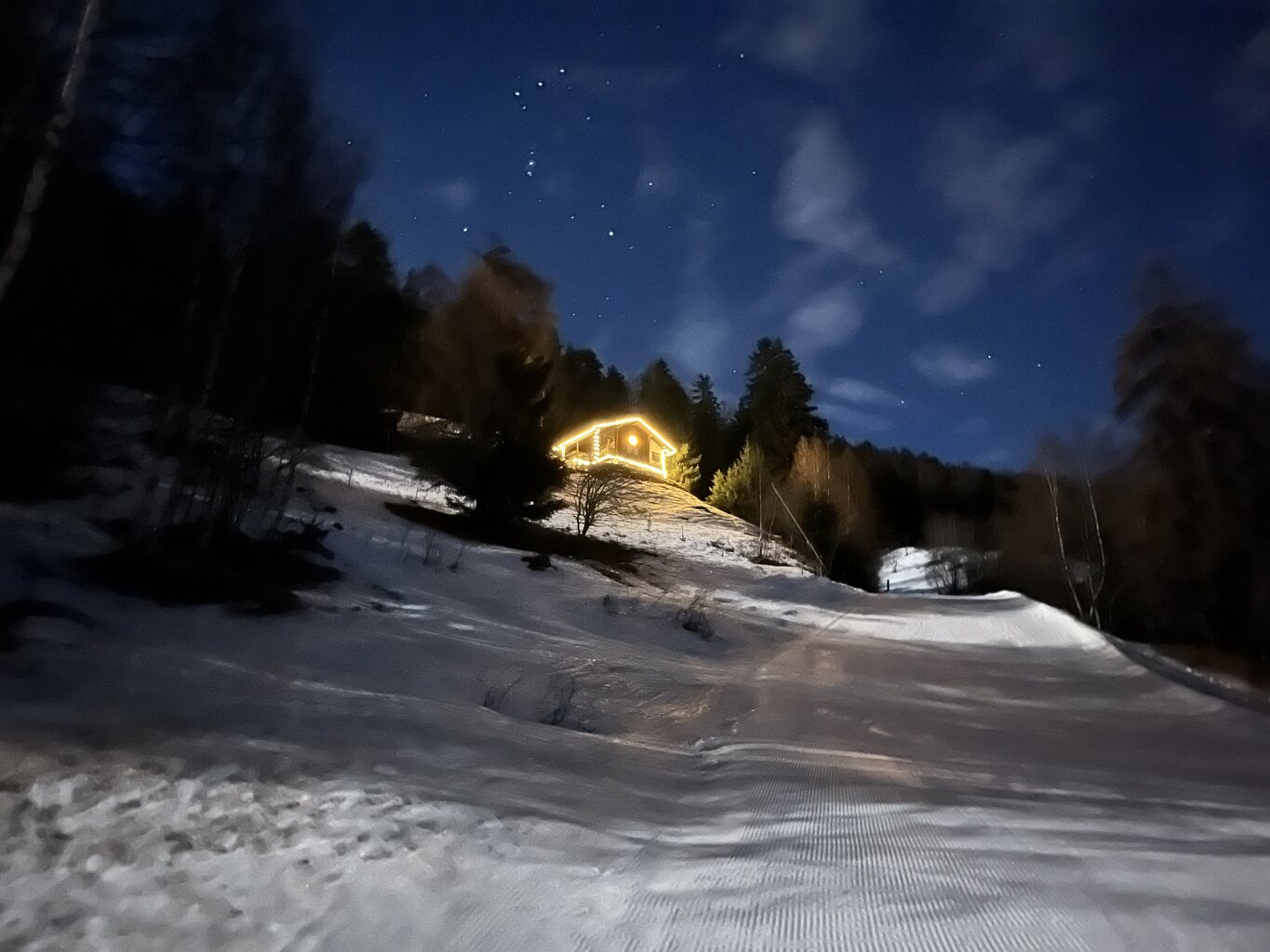 Ein schön beleuchtetes Chalet direkt an der Piste.