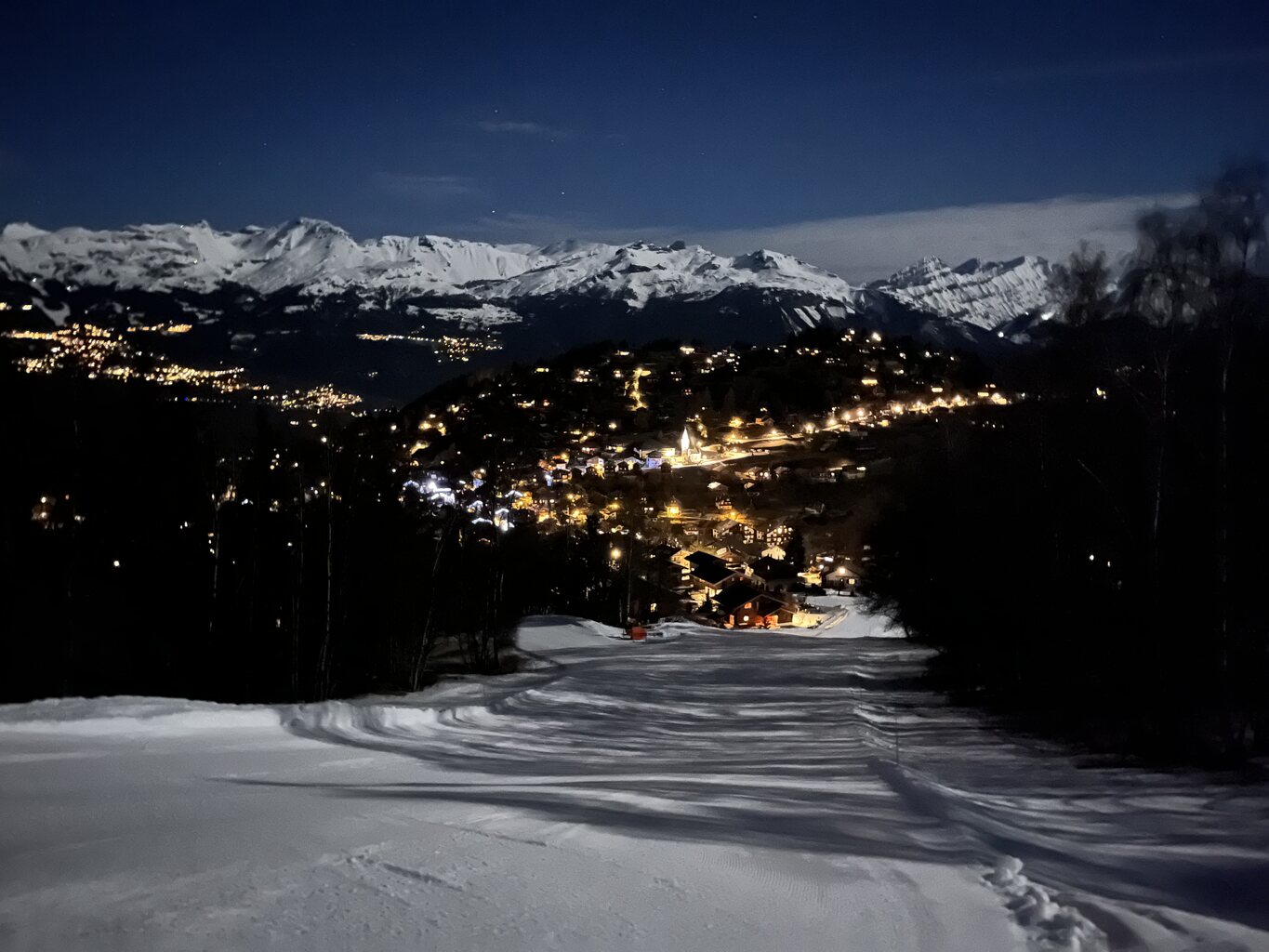 Annäherung an das Dorf mit den schneebedeckten Gipfeln im Hintergrund