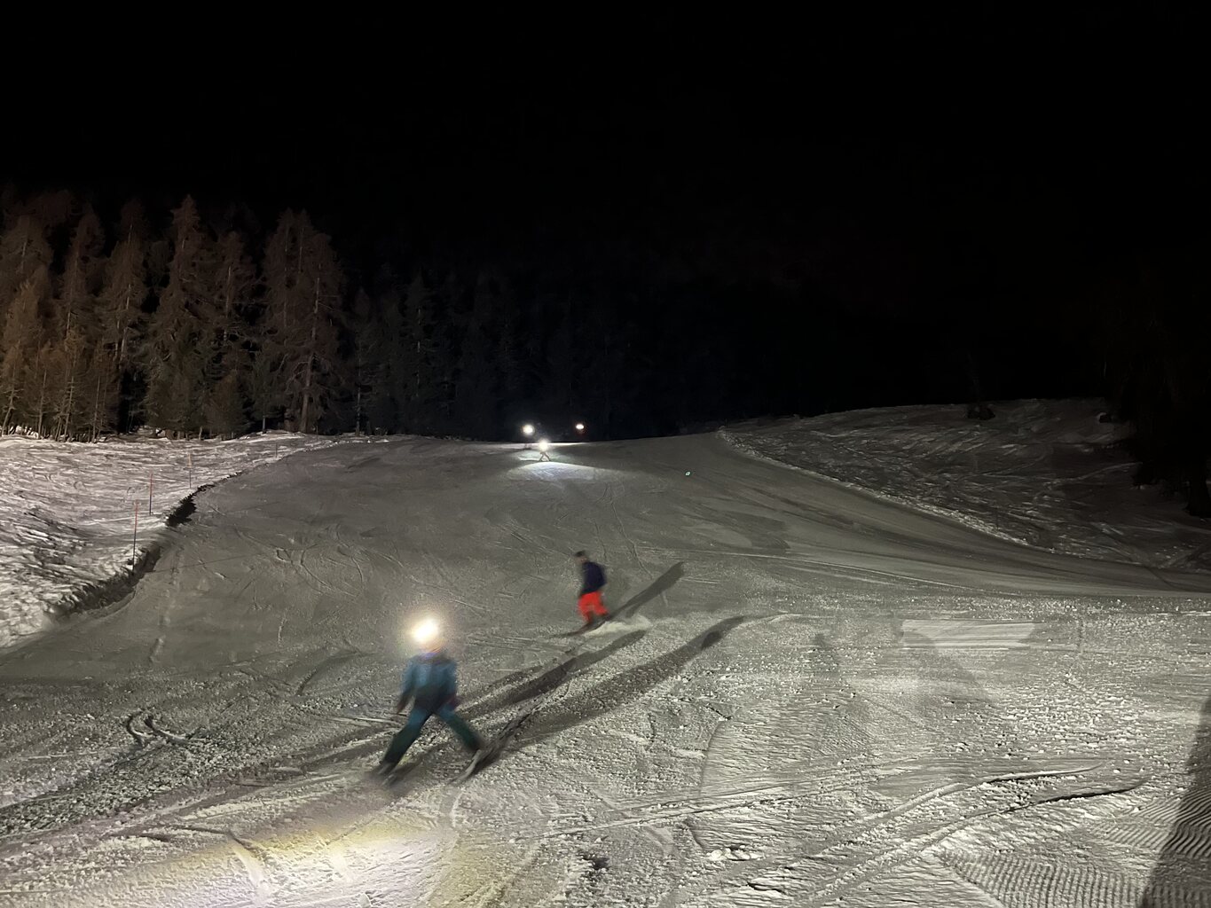 Skifahrer, die mit ihren Scheinwerfern an der Mittelstation der EUB ankommen.