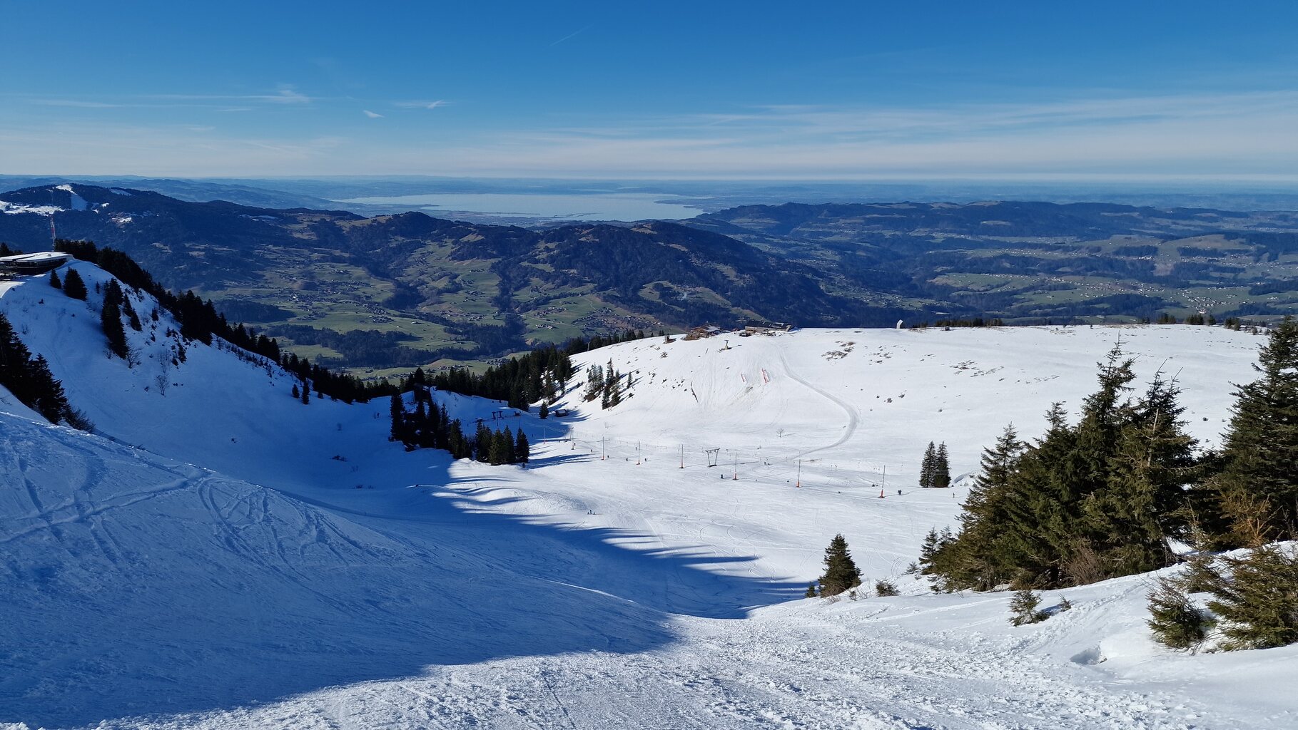 Der Blick über das Skigebiet, welches in einer Mulde gelegen ist mit imposantem Weitblick bis über den Bodensee hinweg.