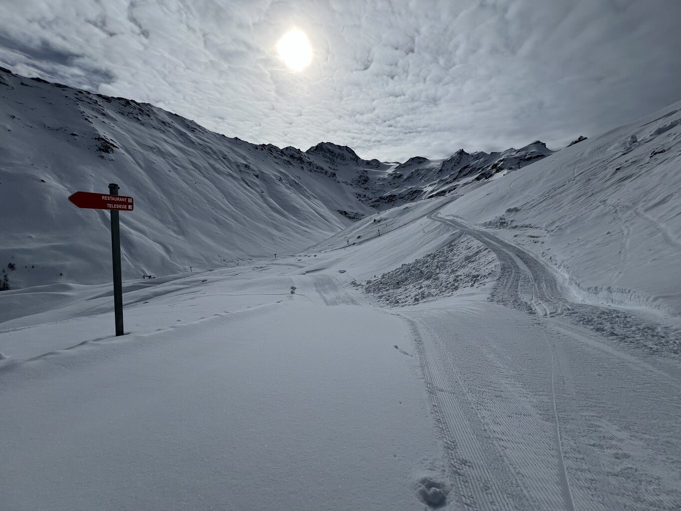 Unterer Teil der rote Piste, geschlossen. Links: Rote Piste, die zum Skilift hinunterführt. Rechts: Ziehweg der von der roten Piste kommt. Dem Schild folgend: Ziehweg, der auf die Route des Maigeonnettes führt.