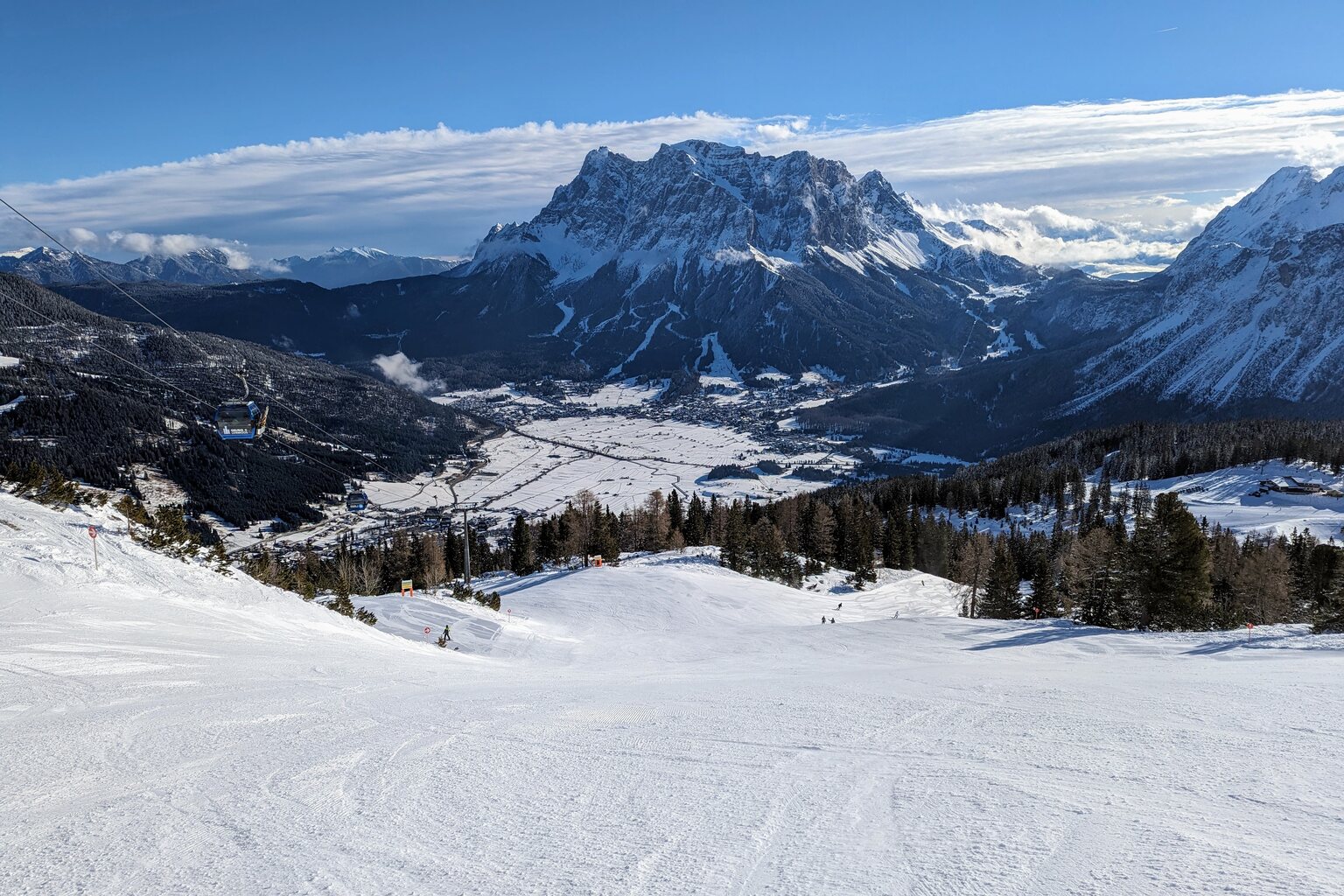 Standardabfahrt (5) im weiteren Verlauf. Ein Stück weiter unten zweigt links der Skiweg zur Wolfratshauser Hütte ab. Rechts zweigt die Waldabfahrt ab. Im Hintergrund das Zugspitz-Massiv.