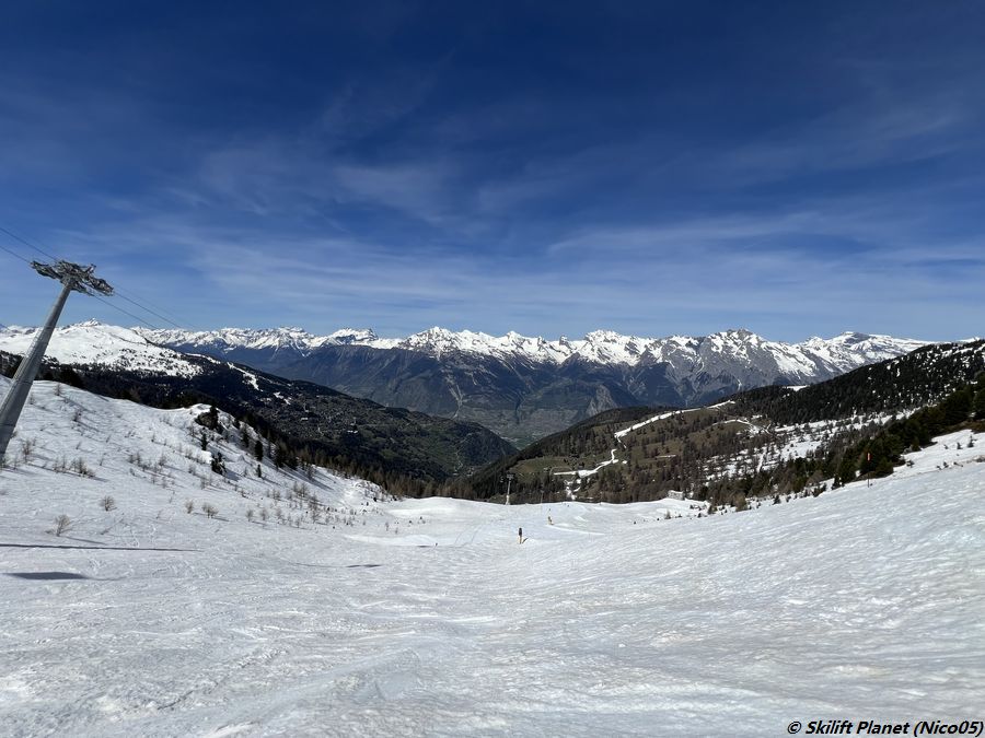 Schwarze Piste Les Fontaines und Blick auf das weiße Band aus Kunstschnee in Prarion