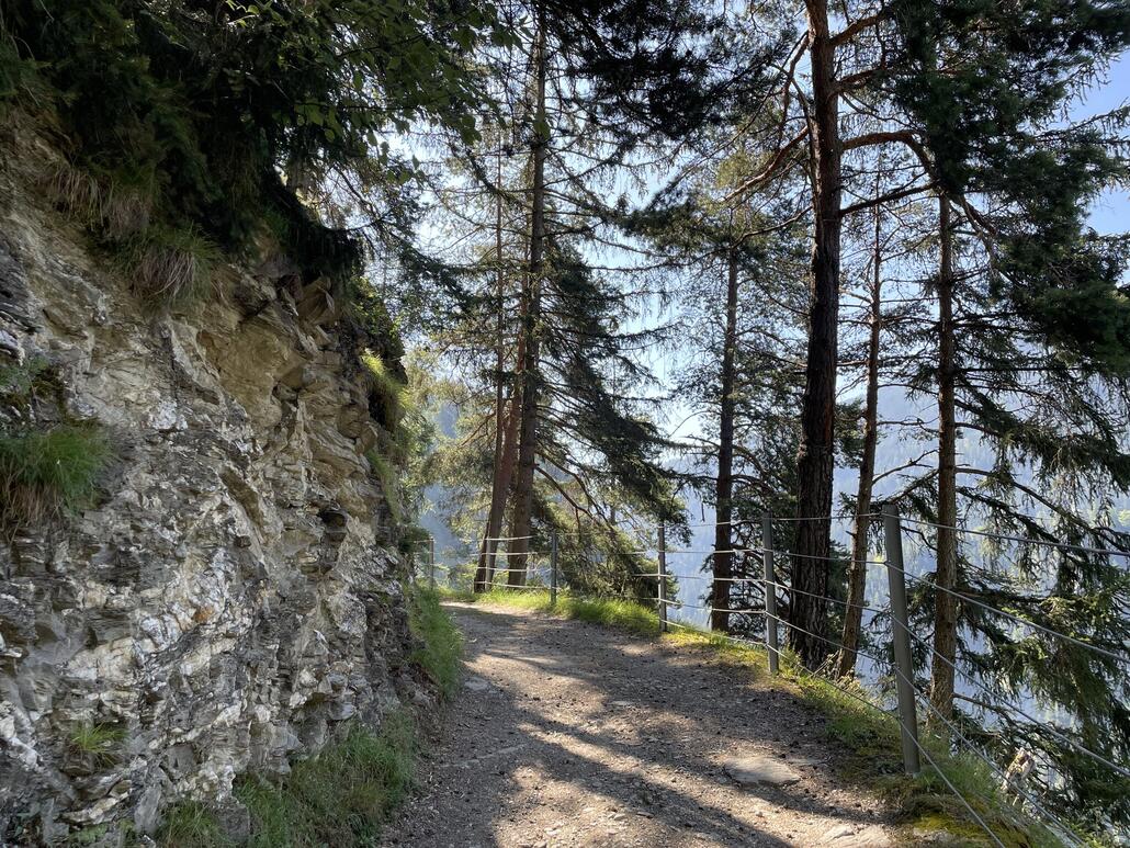 Der von uns befahrene Weg wurde an vielen Stellen massiv in den Hang geschlagen. Talseitig hat es oft eine Absturzsicherung in Form eines Metallzauns.