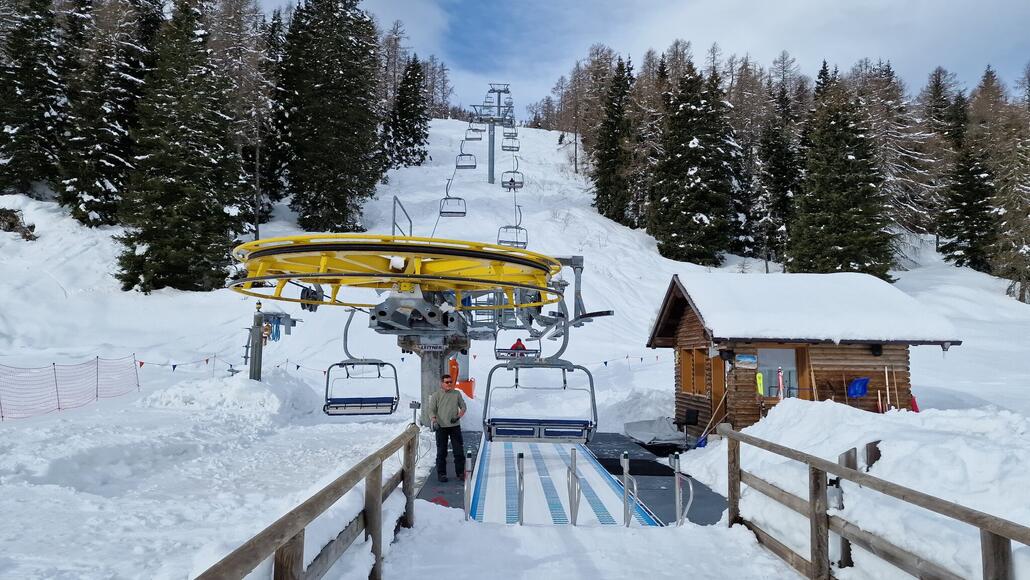 Talstationsbereich der Sesselbahn Laresè. Da sie zum höchsten Punkt des Gebietes führt, ist sie als einzige Anlage mit Sturmsesseln ausgestattet.