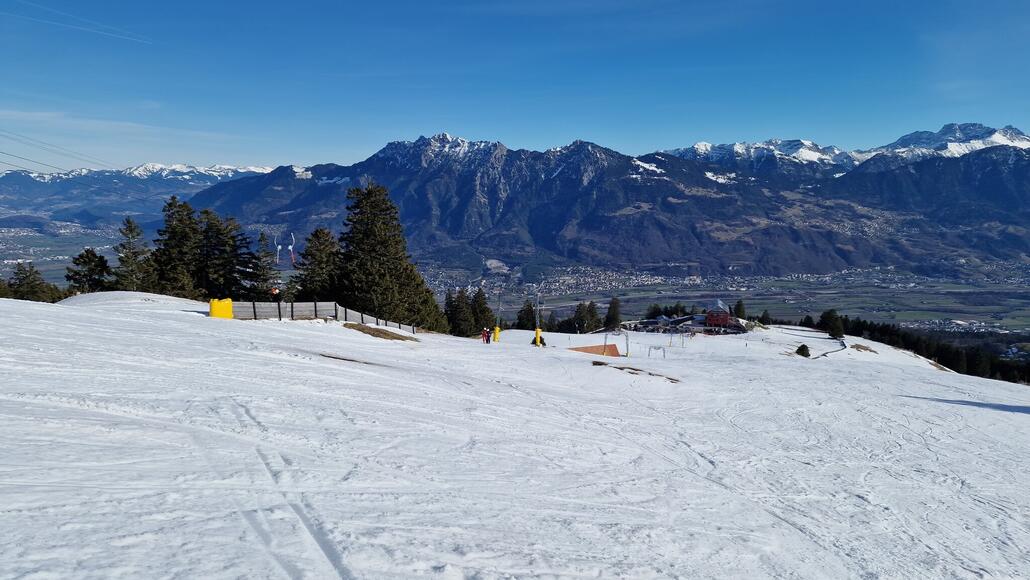 Blick auf das Skiareal. Im Hintergrund das Rheintal und das Fürstentum Liechtenstein auf der gegenüberliegenden Talseite.