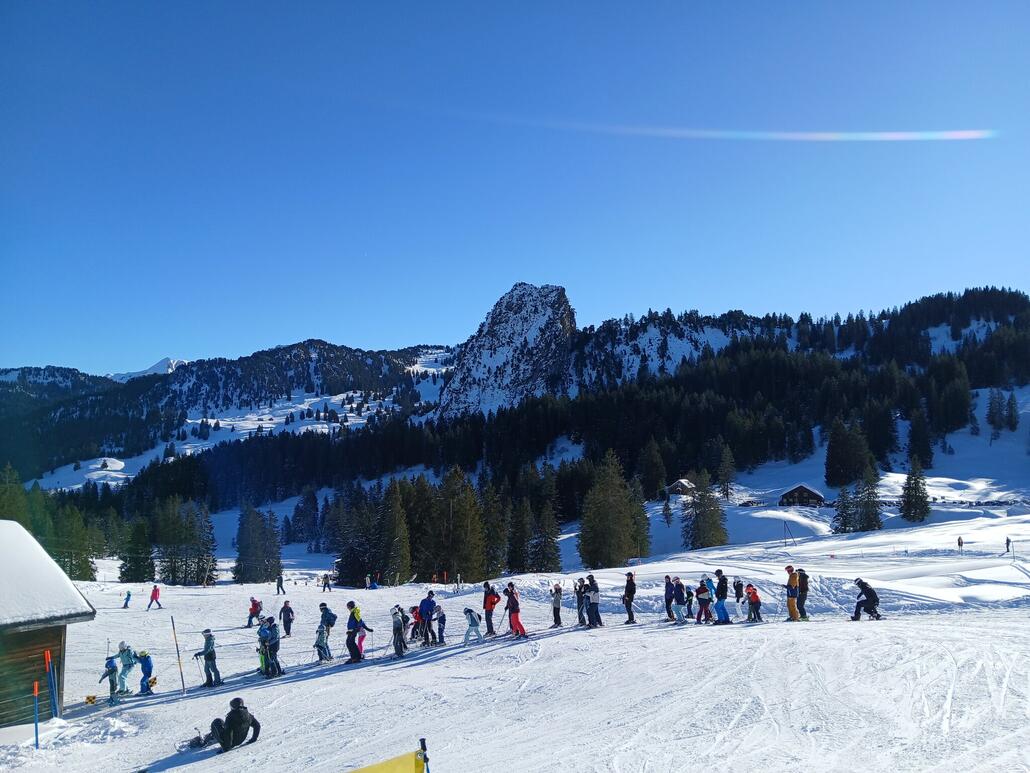 Diesen Felsen muss man umrunden, um zur Ibergeregg zu kommen. Im Vordergrund die Schlange am Lift.