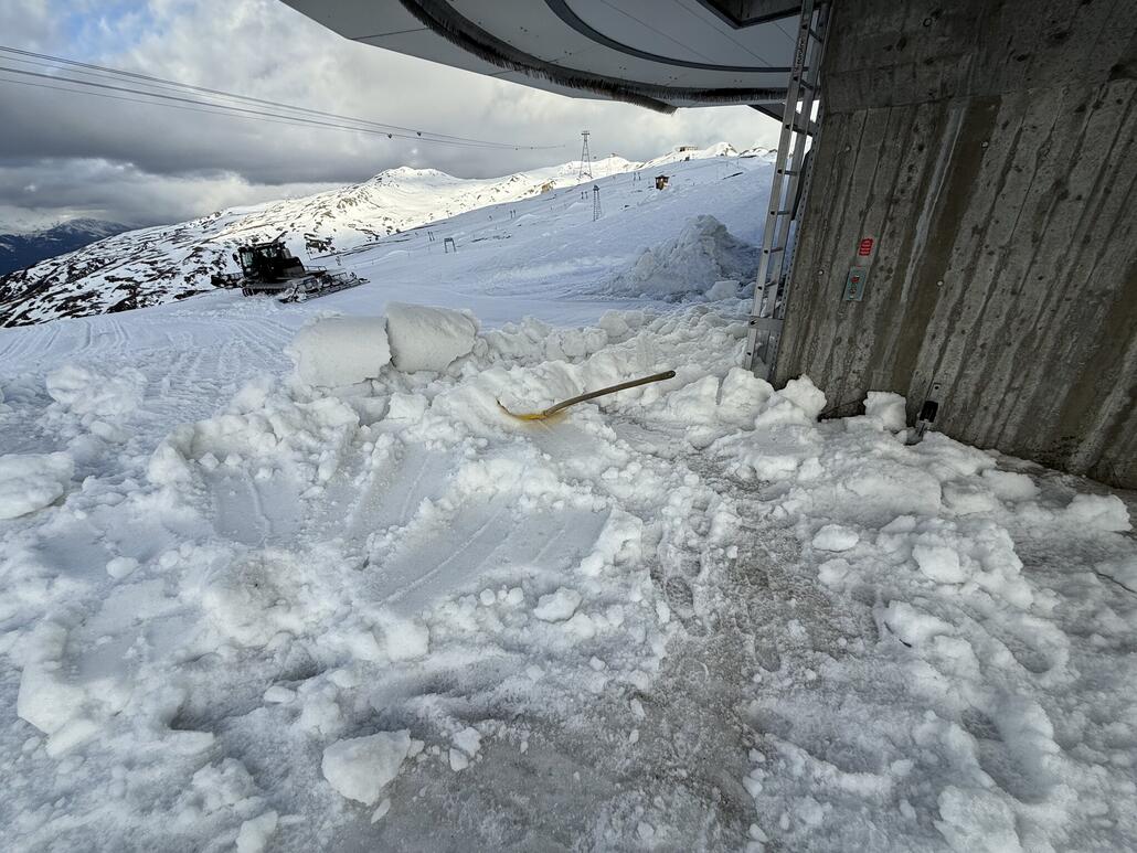 Pistenbully schiebt Schnee vom Platz am Crap Sogn Gion ein (eisiger Sulz)