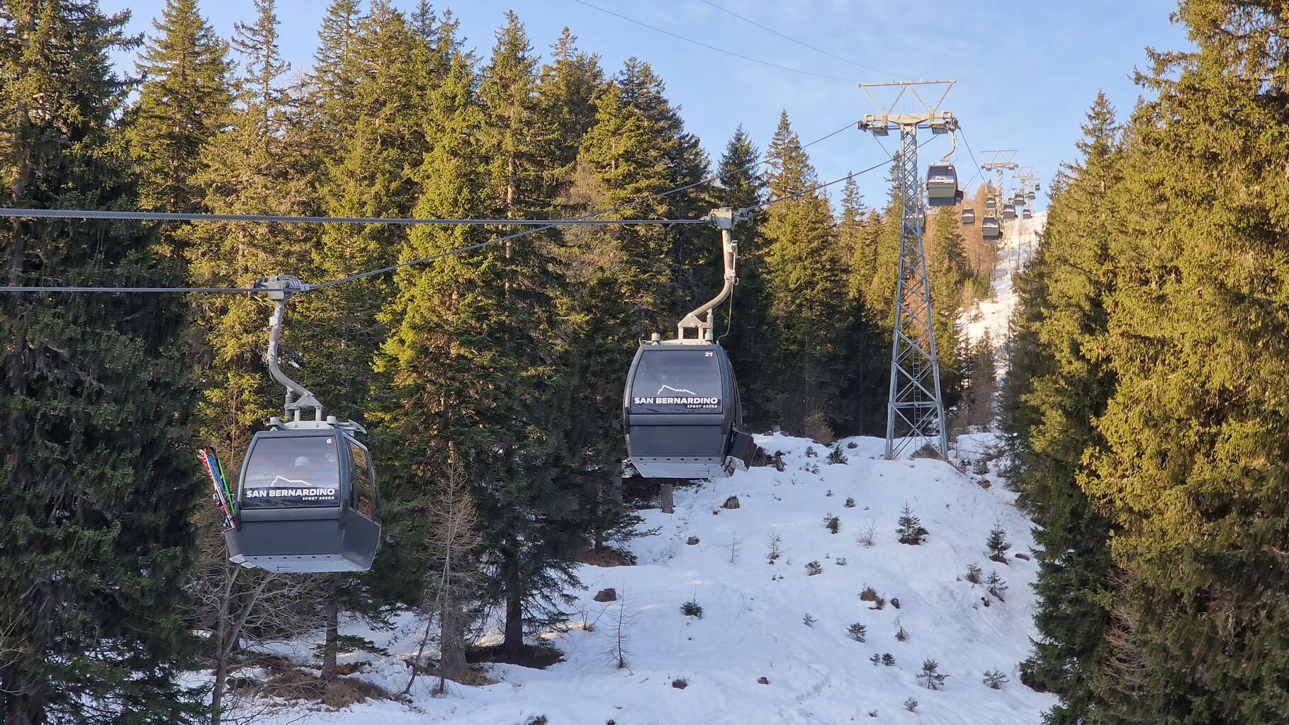 Die erste Kabine mit Wintersportler fährt hoch zum wiedereröffneten Skigebiet Confin.
