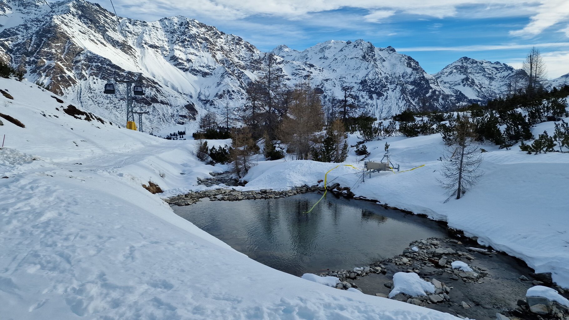 Der Beschneiungsteich mit mobiler Pumpe von Technoalpin. Links die noch geschlossene Talabfahrt.