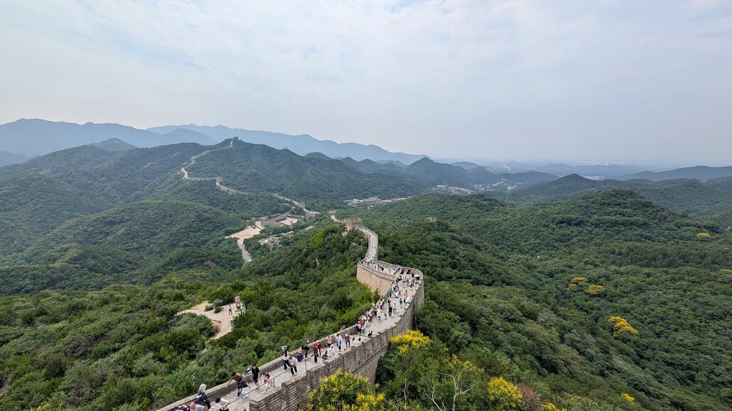 Blick von doer oben ins Tal, man könnte sich einfach die Mauer weiter nach unten laufen und dort zur Talstation kommen. Gegenüber die Südseite, mit dem etwas falscheren Stück. Und von links (Peking) nach rechts zieht sich die Passtrasse und die Bahnstrecke durchs Tal.