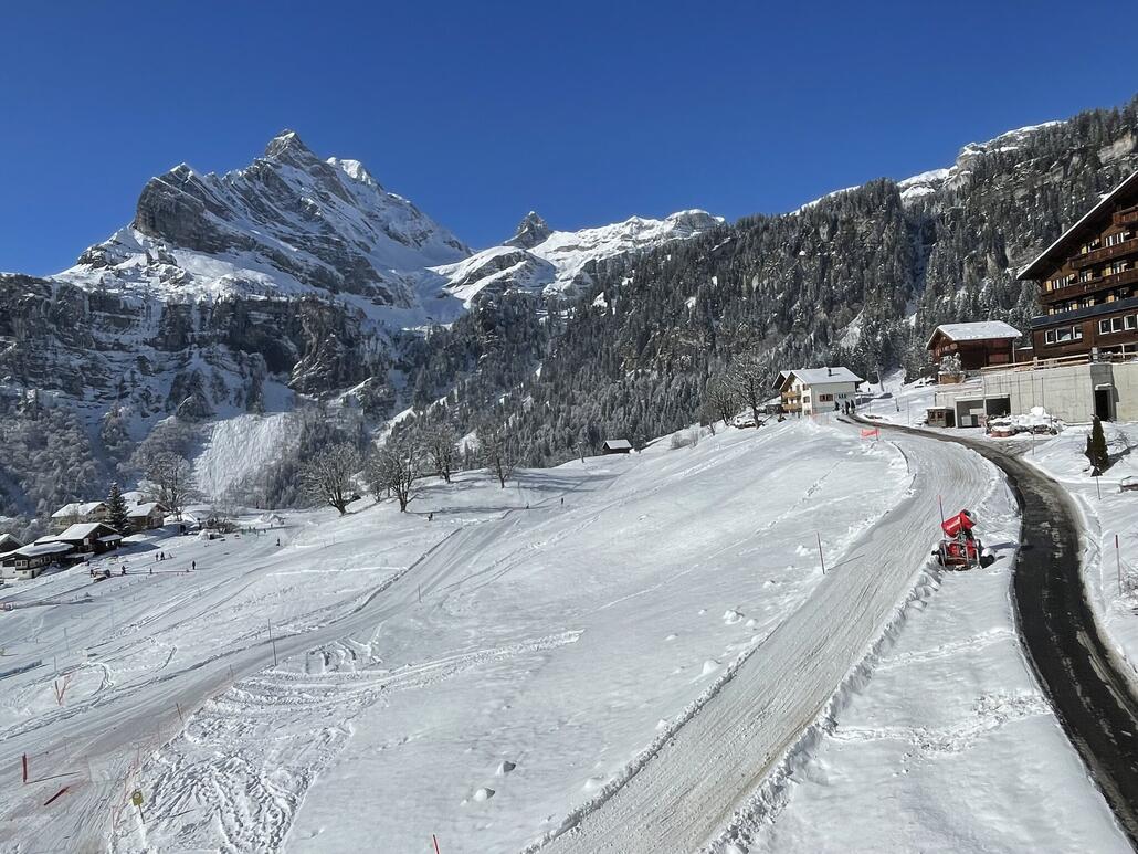 Blick seitwärts auf Piste und Schlittelweg