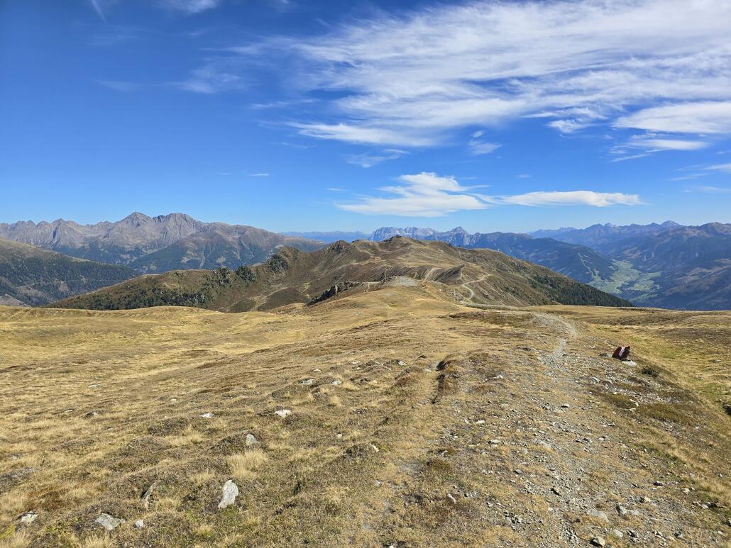 Unterwegs auf dem Trail nahe der Grenze. Im Hintergrund ist die Bergstation der Sesselbahn Thurntaler im Skigebiet von Sillian zu erkennen.