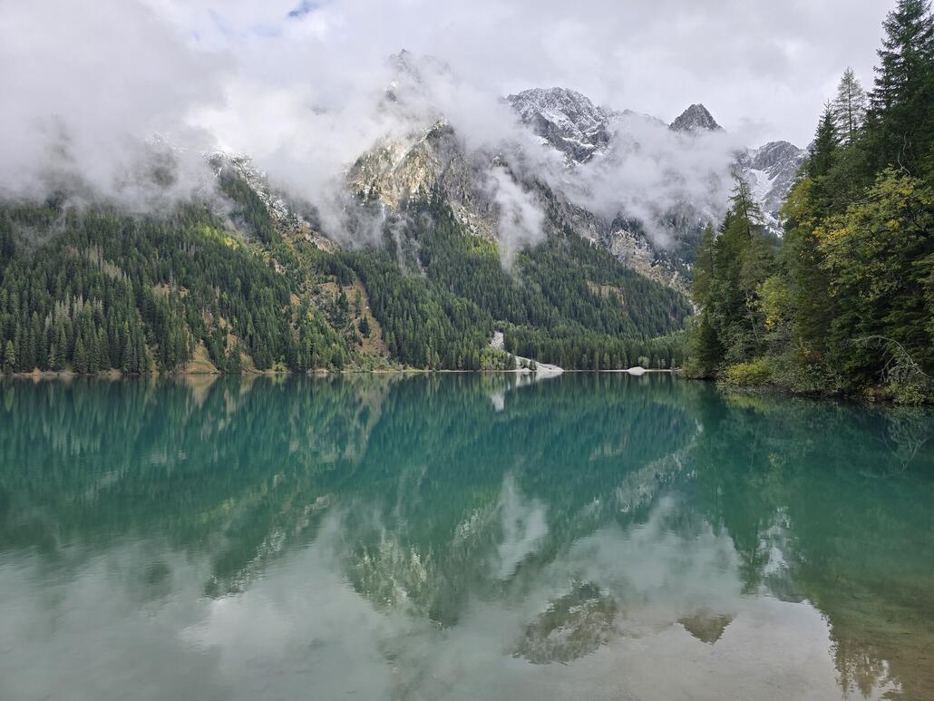 Angelangt beim Antholzersee mit seiner wunderschönen blau-türkisen Farbe. Die Riesenfernergruppe darüber ist jedoch leider teilweise in Wolken.
